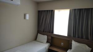 um quarto com 2 camas e uma janela em Solar das Águas - Resort Em Olimpia - Ap 2 quartos em Olímpia
