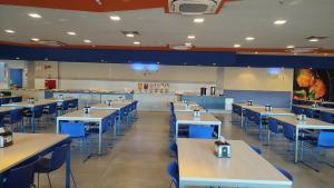 un restaurante con filas de mesas y sillas azules en Solar das Águas - Resort Em Olimpia - Ap 2 quartos en Olímpia