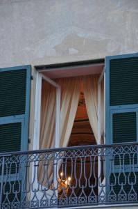 een balkon met een raam en een kroonluchter bij Casa Pagliano in Noli