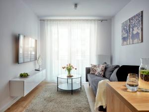 コシャリンにあるA&W Apartament Franciszkańskaのソファとテーブルのあるリビングルーム