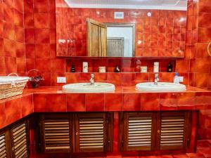 La salle de bains est pourvue de carrelage rouge, de deux lavabos et d'un miroir. dans l'établissement CASA DEL CORSO, à Cinisi