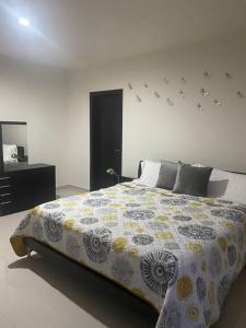 1 dormitorio con 1 cama grande y espejo en Residencia Campo Golf Altozano en Villahermosa