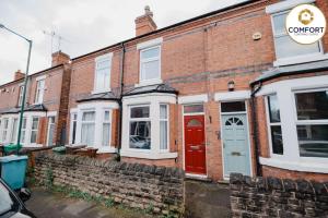 una fila de casas de ladrillo con puertas rojas en 20% off Monthly Stays 2 Bedroom Townhouse en Nottingham