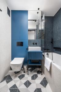 a bathroom with a white toilet and a blue wall at Mokotów Bełska Dream Studio in Warsaw