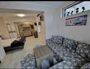 uma sala de estar com um sofá e uma mesa em Guest House Simon Green em Balchik