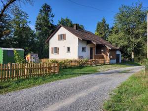 uma casa branca com uma cerca na berma de uma estrada em Ferienhaus in der Natur em Schlossrued