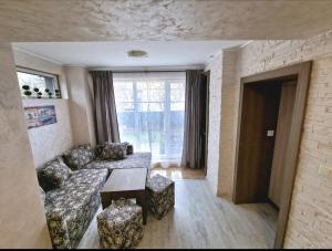 - un salon avec un canapé et une table dans l'établissement Guest House Simon Green, à Balchik