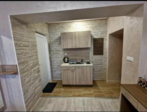 a kitchen with a sink and a brick wall at Guest House Simon Green in Balchik