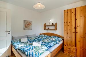 a bedroom with a bed with a blue and white comforter at Reinhards Ferienwohnung in Greifswald