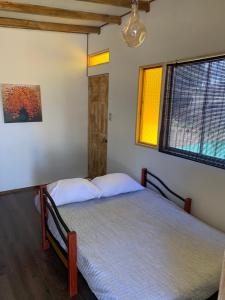 a bedroom with two beds and two windows at Tinyhouse Ecologico con Tinaja in Villa Alemana