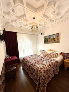 um quarto com uma cama grande e um lustre em Karavansaray Xurjin Old em Bukhara