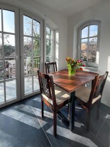 a dining room table with chairs and a vase of flowers at Türmle in Öhningen