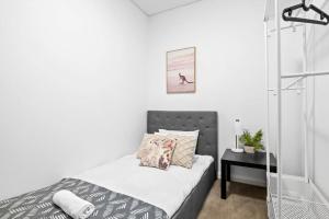 a small bedroom with a bed and a mirror at NEW 3BR Apt in Kingsgrove Sleeps 7 in Sydney