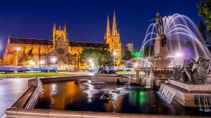 a building with a fountain and a cathedral at night at NEW 3BR Apt in Kingsgrove Sleeps 7 in Sydney