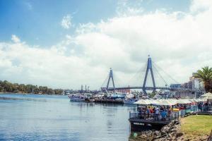 a group of boats docked at a dock on a river at NEW 3BR Apt in Kingsgrove Sleeps 7 in Sydney