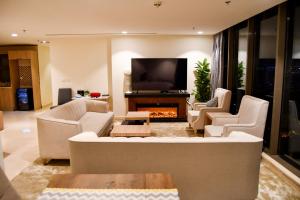 uma sala de estar com um sofá e uma televisão em Stylish and private apartment em Riyadh