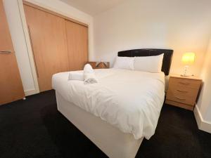 ein Schlafzimmer mit einem großen Bett mit weißer Bettwäsche in der Unterkunft Central Gem 1 Bed Flat City Centre in Glasgow