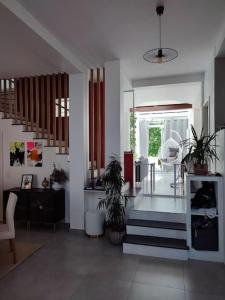 una sala de estar con una escalera y algunas plantas en Large architect-designed house 230 sqm /2475 sqft en Antony