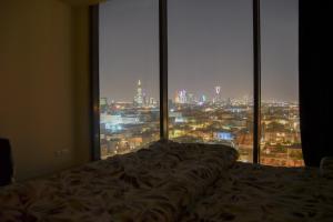 uma cama num quarto com vista para a cidade em Stylish and private apartment em Riyadh