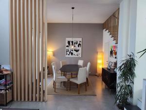 een eetkamer met een tafel en witte stoelen bij Large architect-designed house 230 sqm /2475 sqft in Antony