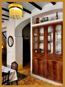 a room with a wooden cabinet with dishes in it at Oliva Courtyard Guesthouse in Oliva