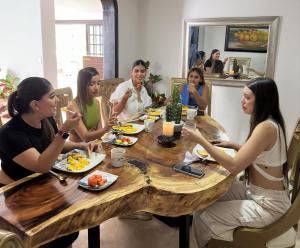 un grupo de personas sentadas alrededor de una mesa comiendo comida en The View Hostel & Lounge en Cali