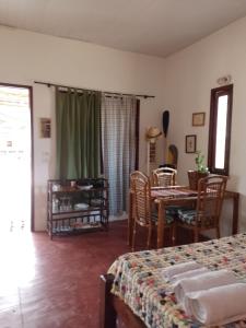 Habitación con cama, mesa y sillas. en CHALE PERTO DA PRAIA COM DUAS SUITES E VARANDAO, en Pacatuba
