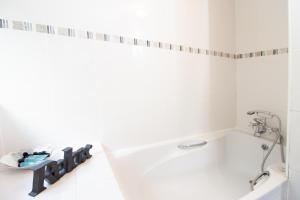 a white bathroom with a tub and a sink at OPP Exeter - Cosy 1 bed with parking, BIG SAVINGS booking 7 nights or more! in Exeter