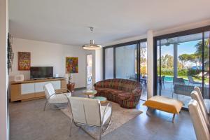 uma sala de estar com um sofá e cadeiras em Villa U Spanu em Lumio