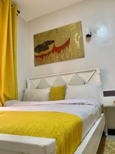 a bedroom with a bed with a yellow blanket at Rorot 1 bedroom Modern fully furnished space in Annex Eldoret with free wifi in Eldoret