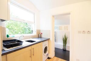 a kitchen with a sink and a washing machine at OPP Exeter - Cosy 1 bed with parking, BIG SAVINGS booking 7 nights or more! in Exeter