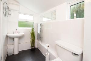 a white bathroom with a sink and a mirror at OPP Exeter - Cosy 1 bed with parking, BIG SAVINGS booking 7 nights or more! in Exeter