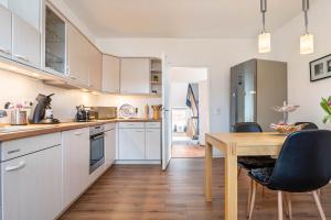 eine Küche mit weißen Schränken und einem Holztisch in der Unterkunft Ferienwohnung Glückauf in Castrop-Rauxel