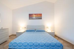 - une chambre avec un lit bleu et 2 tables de chevet dans l'établissement Villetta Cenzina, à Olìa Speciosa