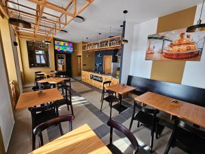 a restaurant with wooden tables and chairs and a bar at Ubytování Jeřábek in Lasenitz