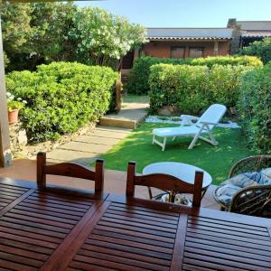 un patio con tavolo e sedie in un cortile di PM 22 Via Cala Sabina Guest House a Stintino