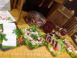 einen Tisch mit Speisen mit Salat und Fleisch in der Unterkunft Hotel Martina in Żnin