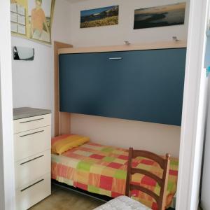 Habitación pequeña con cama y escritorio. en PM 22 Via Cala Sabina Guest House, en Stintino