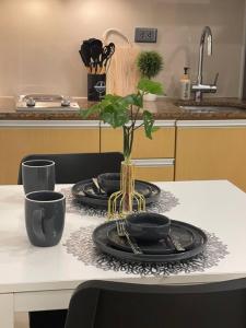 een tafel met twee platen en een vaas met een plant bij Relaxing Studio Unit in Taguig in Manilla