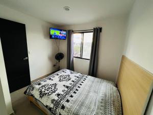 a bedroom with a bed and a tv on the wall at Habitación en Querétaro Capital in Tlacote el Bajo