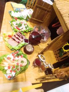 einem Holztisch mit verschiedenen Arten von Speisen in der Unterkunft Hotel Martina in Żnin