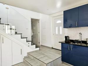 a kitchen with white and blue cabinets and a staircase at Casa D´Aldeia - Carrapateira in Aljezur