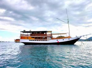 un bateau assis dans l'eau sur l'océan dans l'établissement Open Trip Komodo 3D2N, à Labuan Bajo