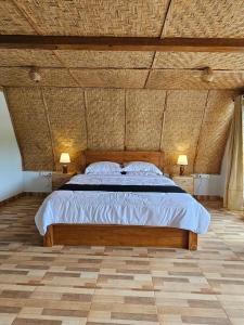 a bedroom with a large bed with a wooden ceiling at UmaUthu Bali in Tabanan