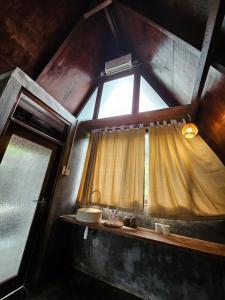 ein Bad mit einem Fenster mit einem Waschbecken und einem Waschbecken in der Unterkunft UmaUthu Bali in Tabanan
