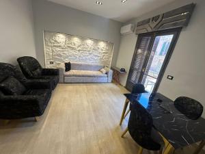 a living room with a couch and a table and chairs at MidtownTahrirViewSuites in Cairo