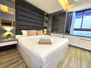 Un dormitorio con una gran cama blanca y una ventana en Loft Suite Seaview near JB CIQ 6-7Pax en Johor Bahru