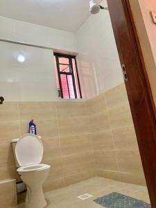 a bathroom with a toilet and a window at Rorot 1 bedroom Modern fully furnished space in Annex Eldoret with free wifi in Eldoret