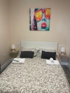 um quarto com uma cama com um quadro na parede em Pisito de la Lola Flores em Santiponce