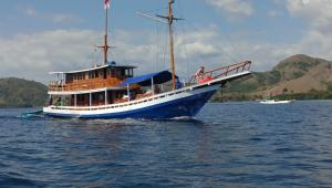 a blue and white boat in the water at Open Trip Komodo 3D2N in Labuan Bajo